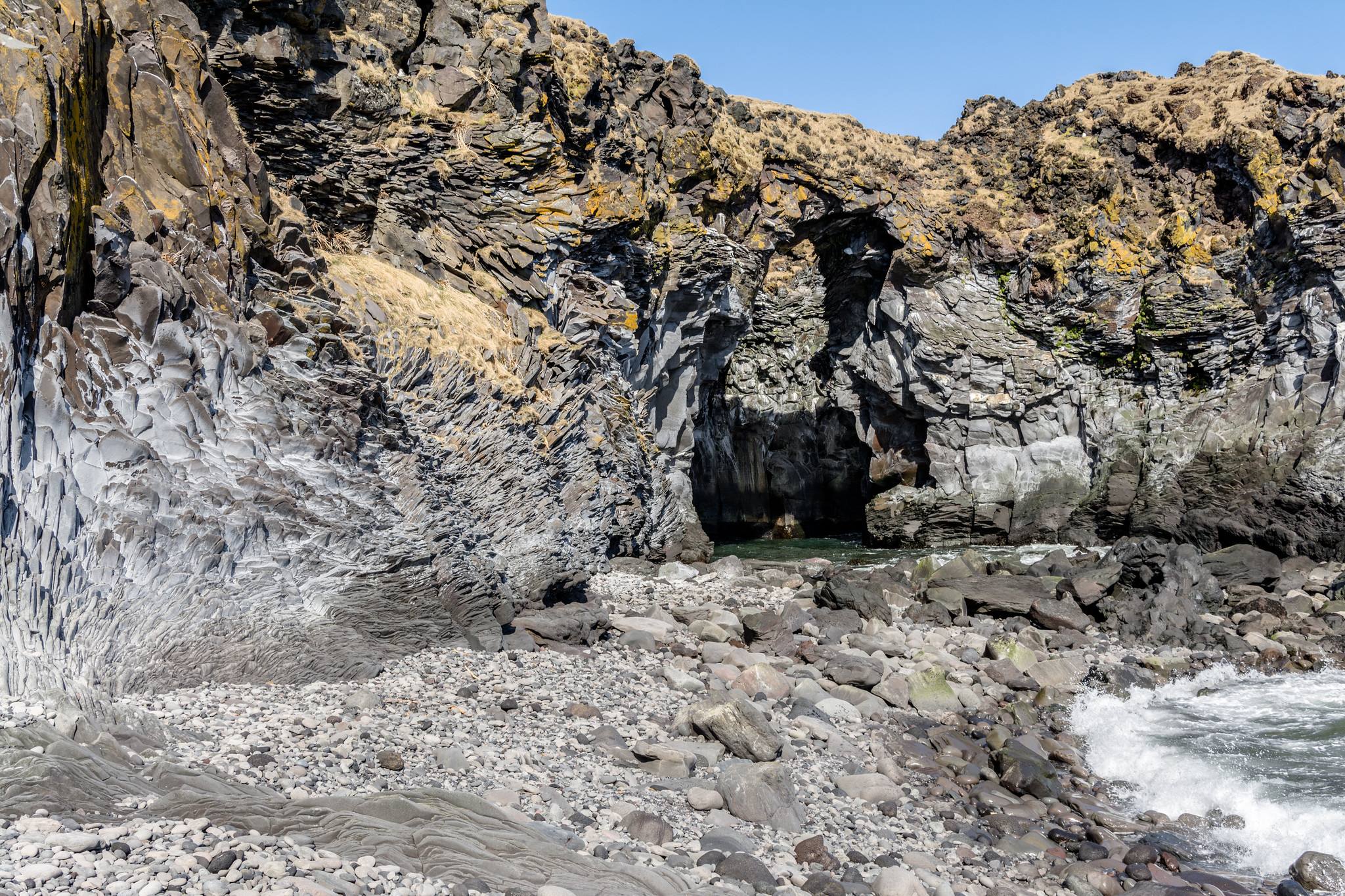 The Baðstofa sea cave and the pebble cove at Hellnar